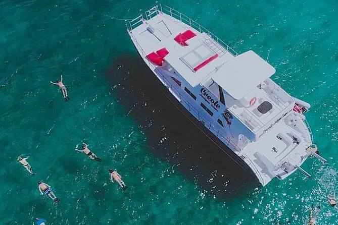 Catamaran anchored off a reef for a beachside lobster lunch on an antigua and barbuda snorkeling cruise to Cades Reef from Jolly Harbour